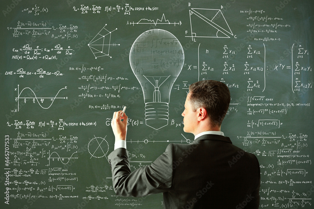 Attractive young european man drawing abstract lamp sketch with mathematical formulas on chalkboard/