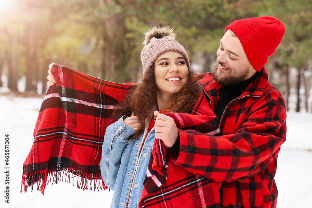 Happy young couple in forest on winter day