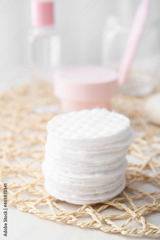 Wicker mat with cotton pads on table, closeup