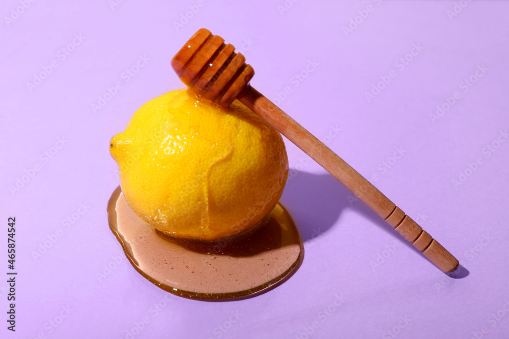 Ripe lemon with honey and dipper on color background