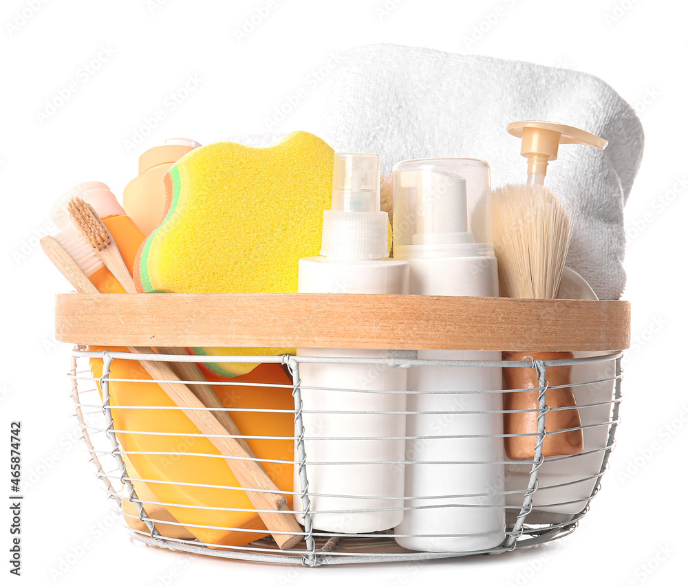 Basket with towel, bath supplies and sponge on white background