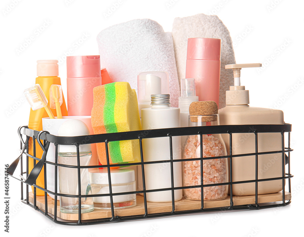 Metal basket with towels, bath supplies and sponge on white background