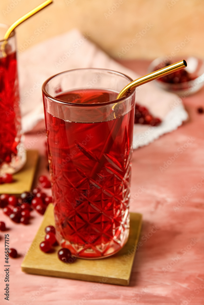 Glass with tasty cranberry juice on color background