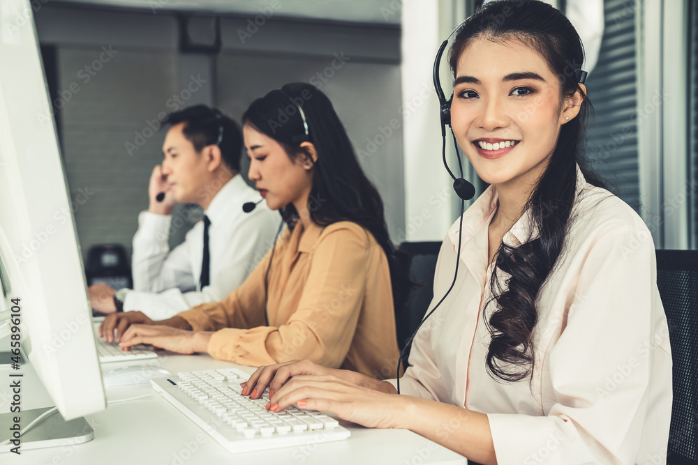 Business people wearing headset working actively in office . Call center, telemarketing, customer su