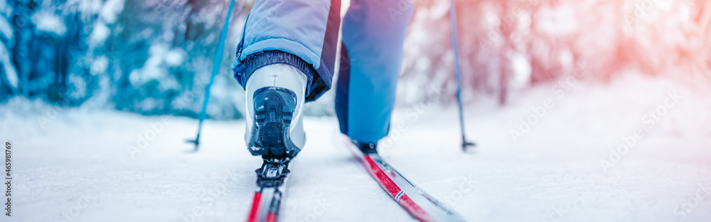 Skier foots in skis in the snowy winter forest