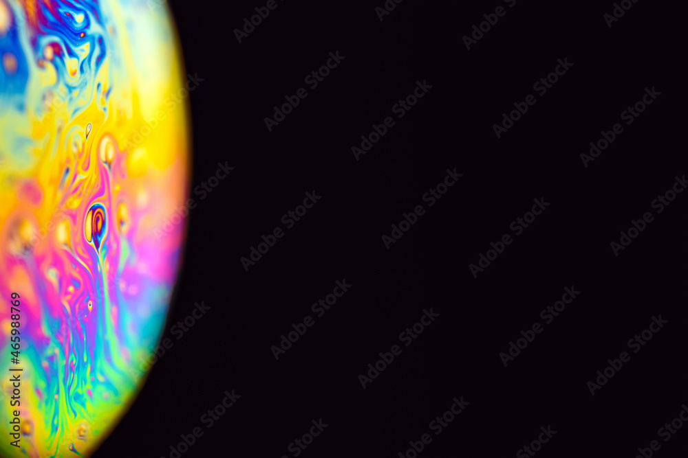 Abstract multicolor psychedelic planet. Closeup Soap bubble like an alien planet on dark background