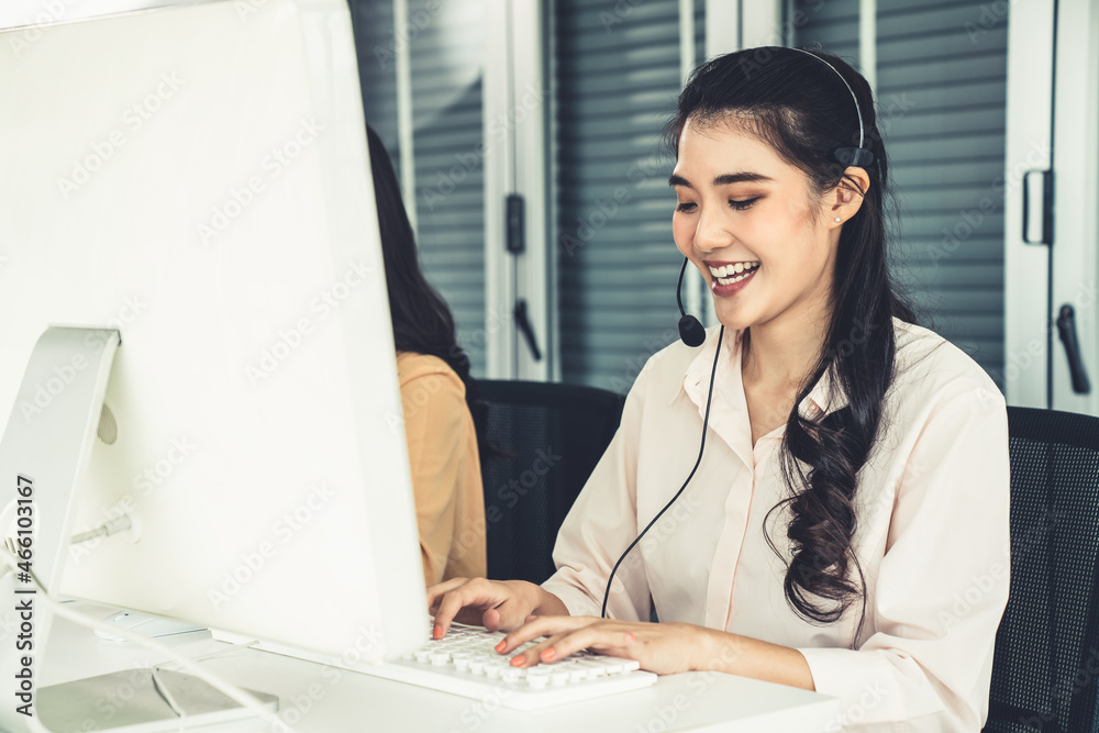 Businesswoman wearing headset working actively in office . Call center, telemarketing, customer supp