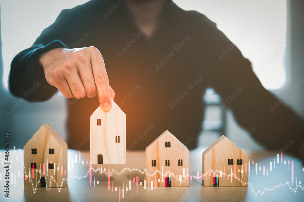 Man hand choosing mini wood house model from model on wood table, Planning buy Real Estate, Planning