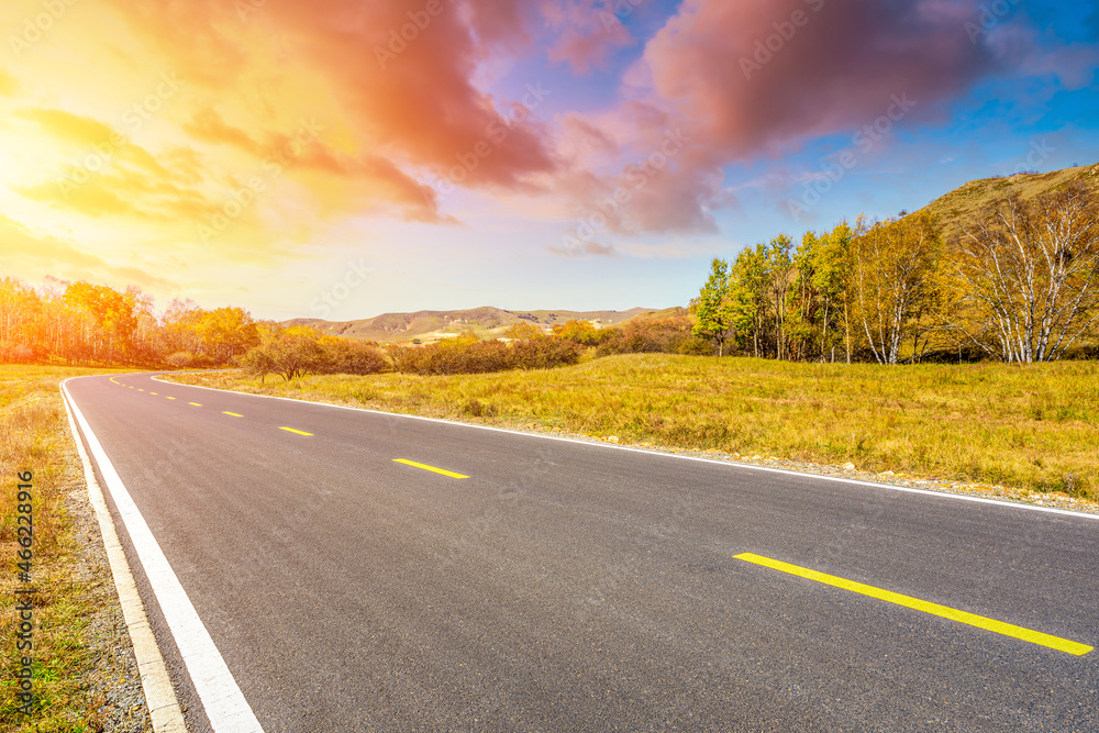 Asphalt road and mountain nature landscape at sunrise.Road and mountain with trees scenery in autumn