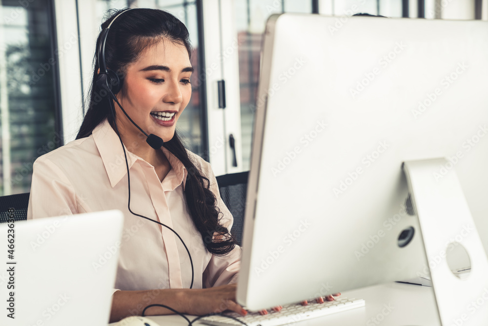 Businesswoman wearing headset working actively in office . Call center, telemarketing, customer supp