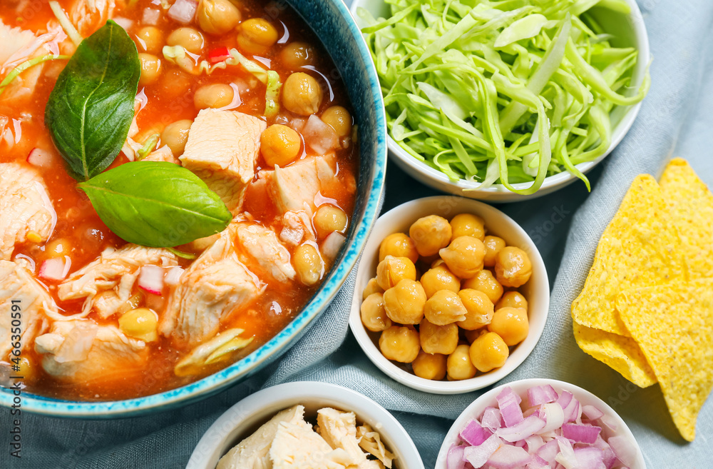 Delicious homemade pozole soup and ingredients on table, closeup