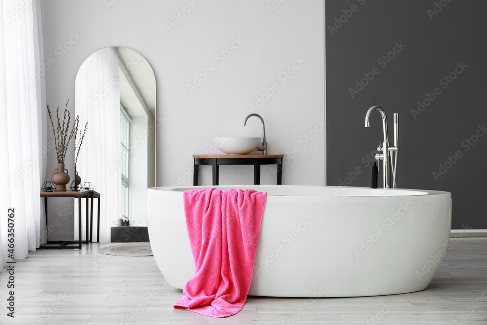 Interior of modern room with mirror and bathtub