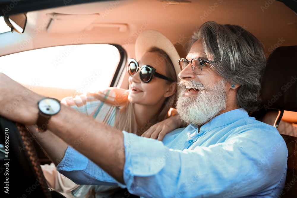 Happy mature couple traveling by car