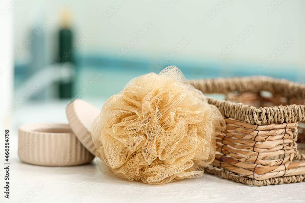 Bath sponge, basket and jar on table in bathroom, closeup