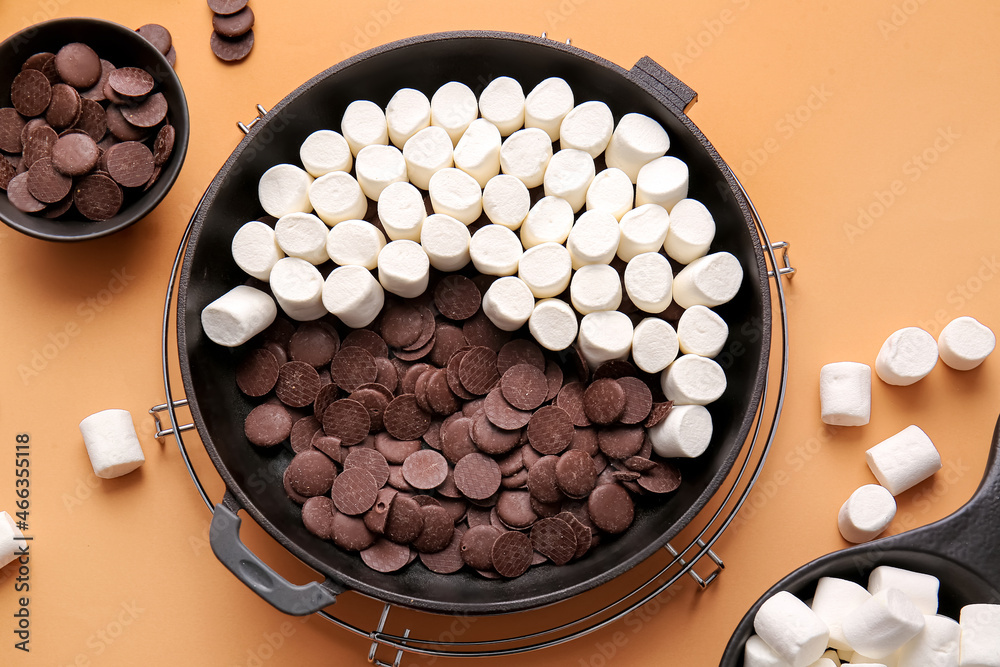 Frying pan with uncooked Smores dip on color background