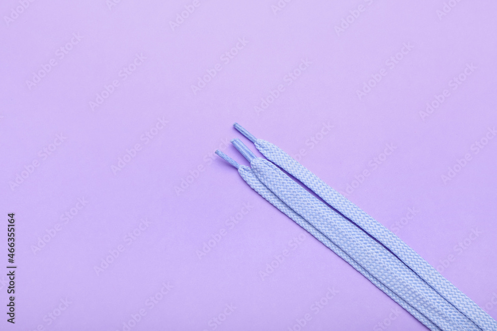 Shoe laces on lilac background, closeup