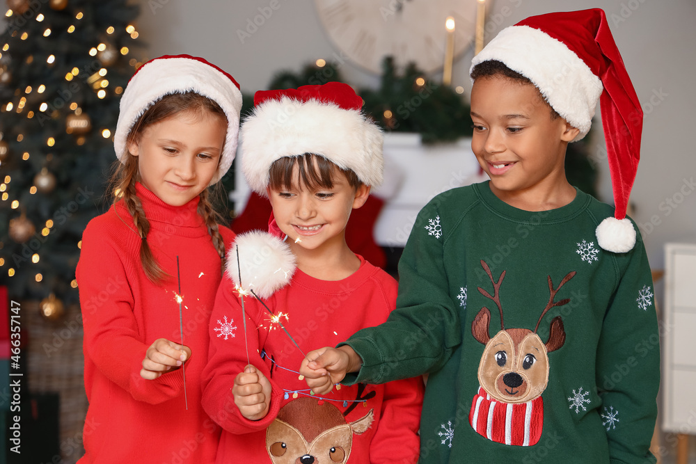 Cute little children with sparklers at home on Christmas eve