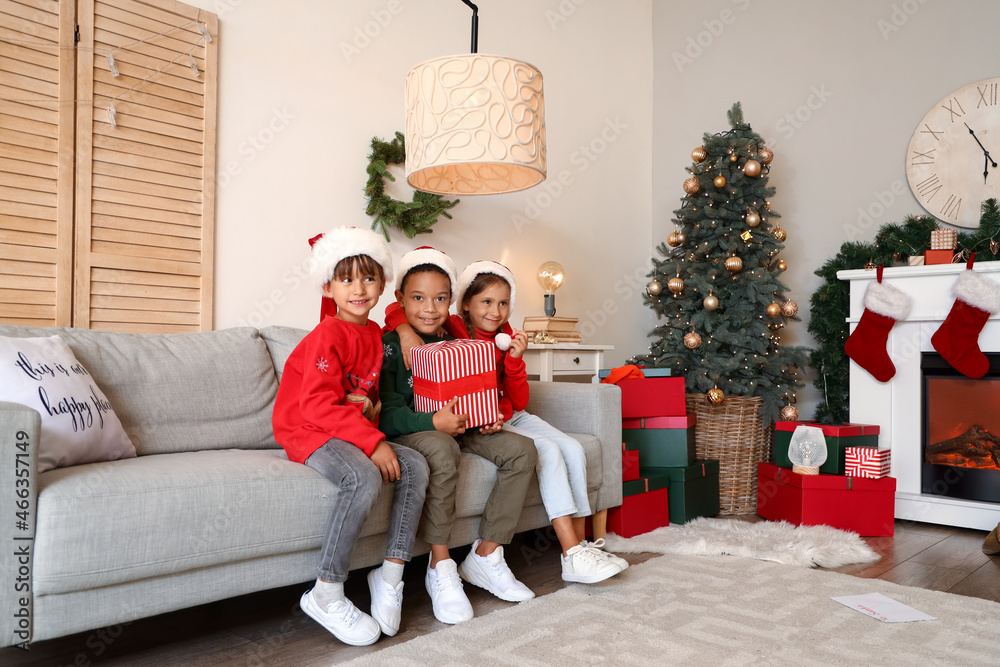 Cute little children with gift at home on Christmas eve