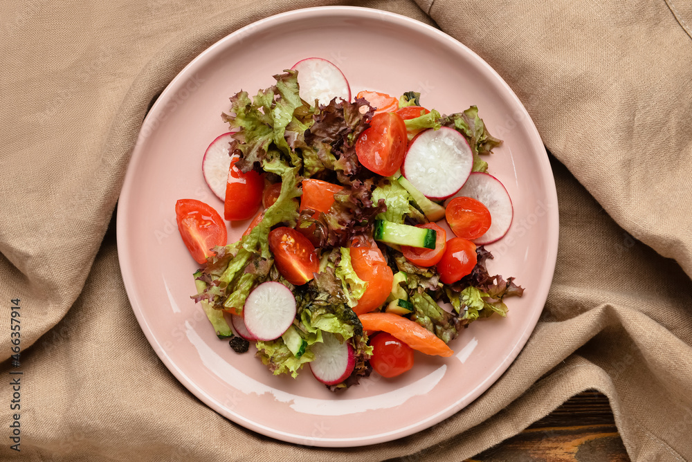 Fresh salad with salmon and vegetables on table