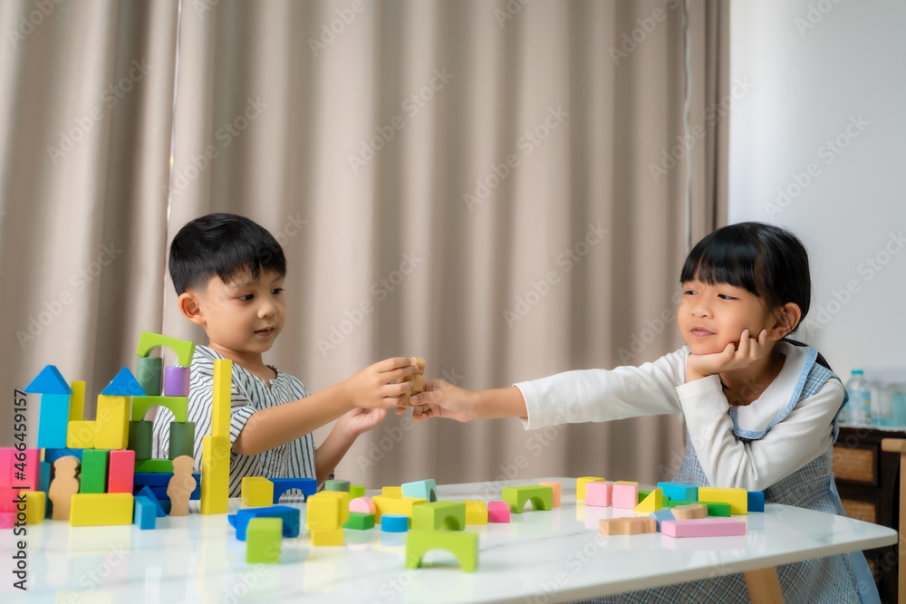 儿童教育玩具，可爱的小女孩和男孩在家里玩玩具积木。