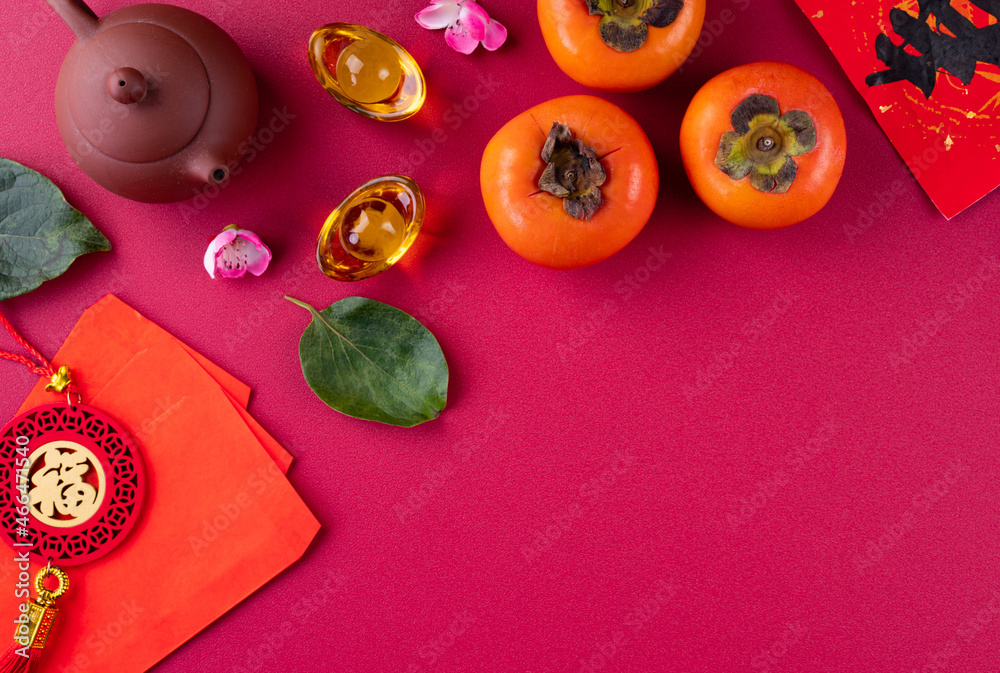 Top view of fresh sweet persimmons with leaves on red table background for Chinese lunar new year