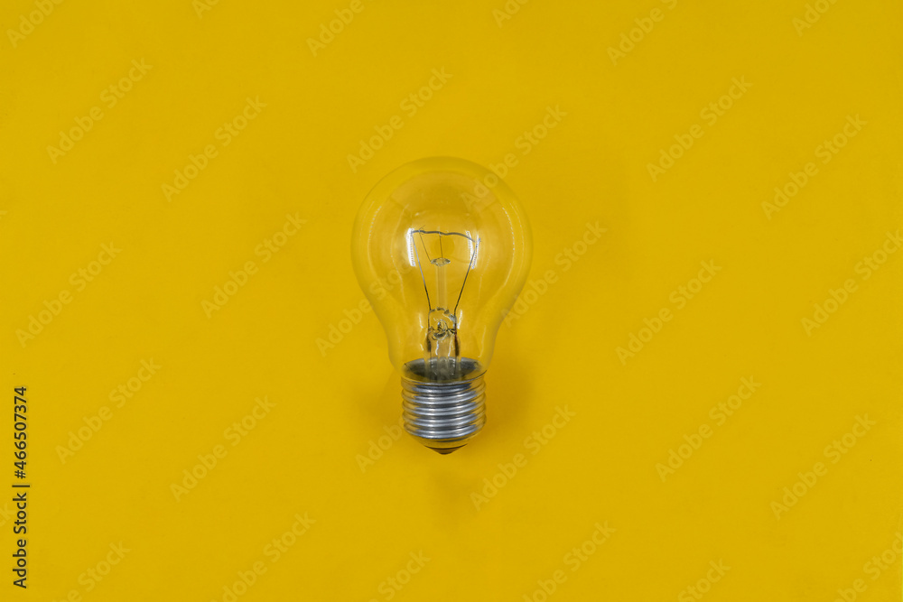 Electric light bulb on yellow paper background