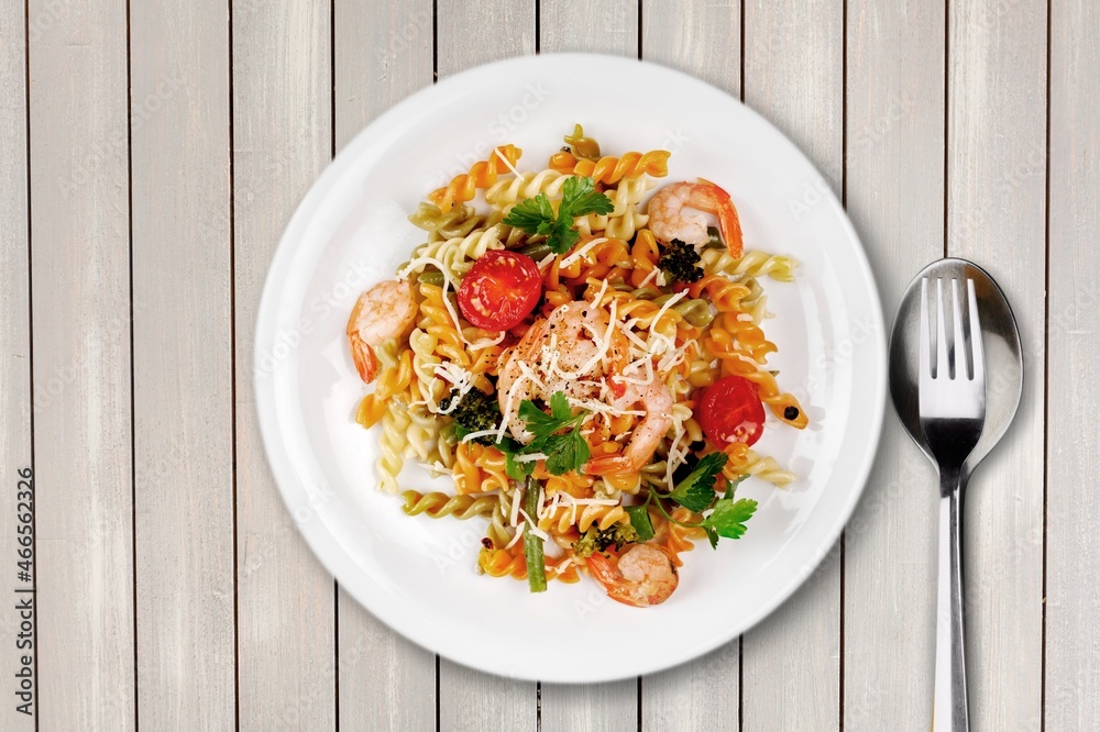 Pasta with cherry tomatoes, cheese and basil on a light plate