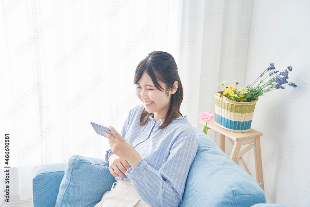 女性　スマホを見る　リビング