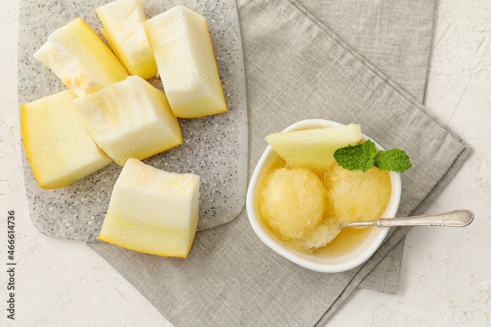 Bowl with tasty sorbet, melon pieces and mint on light background