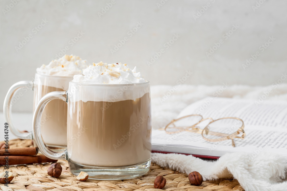 Glass cups of tasty latte with nuts on white background