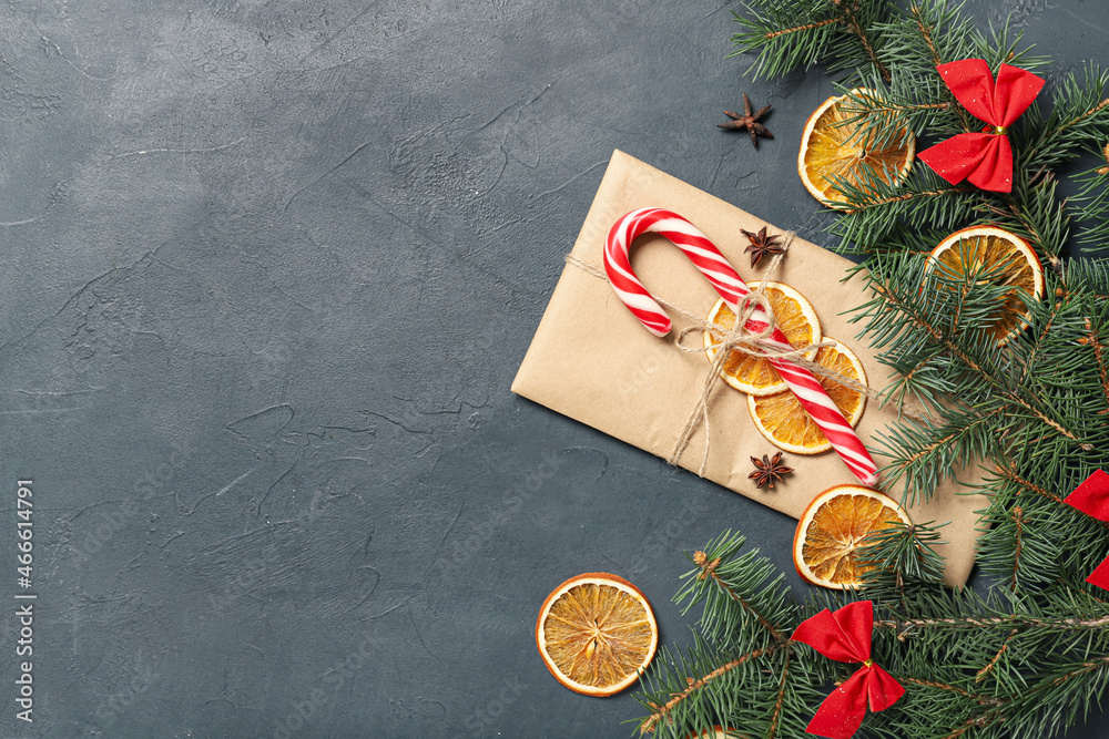 Composition with Christmas gift and fir branches on dark background, closeup