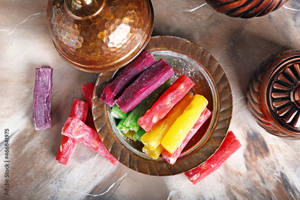 Plate with tasty Turkish delight on marble background