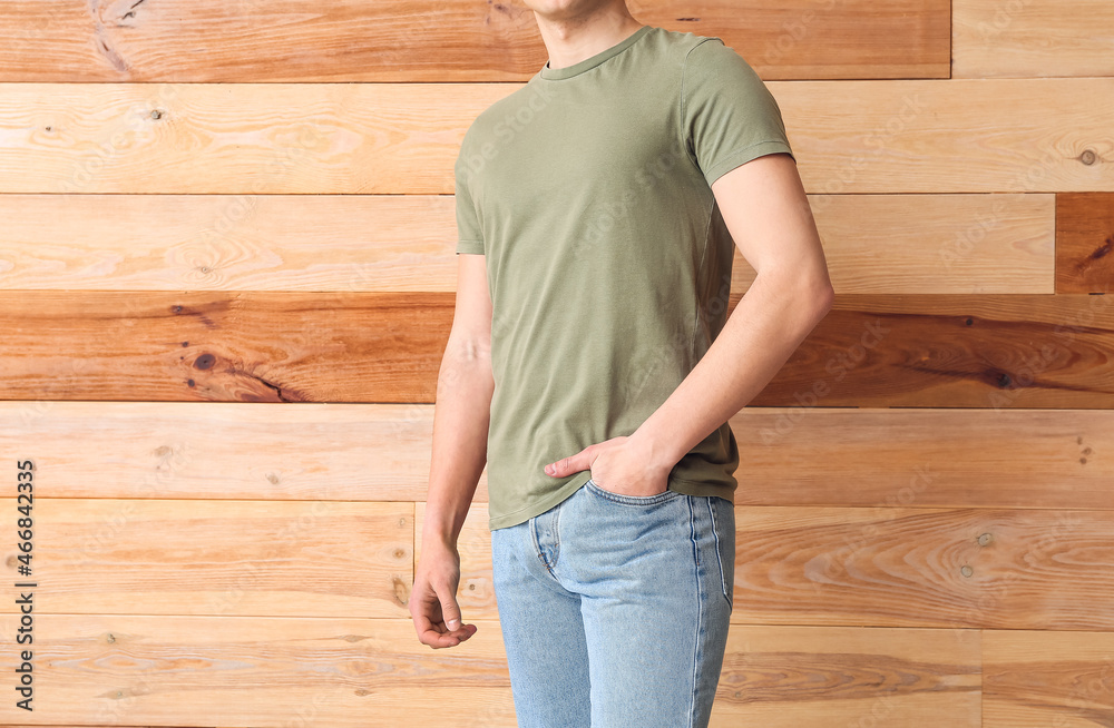 Handsome young man in stylish t-shirt on wooden background