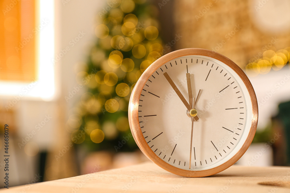 Christmas fairy time. Stylish alarm clock on blurred room interior background