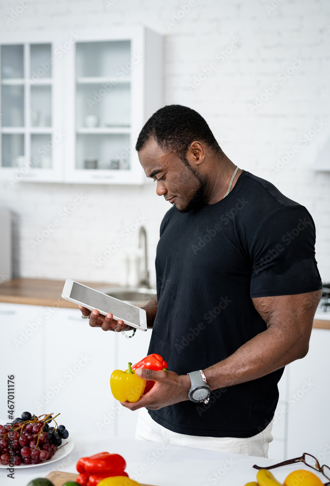 Young handsome man with fruits on the kitchen. Healthy fresh food holding in man hands indoor.