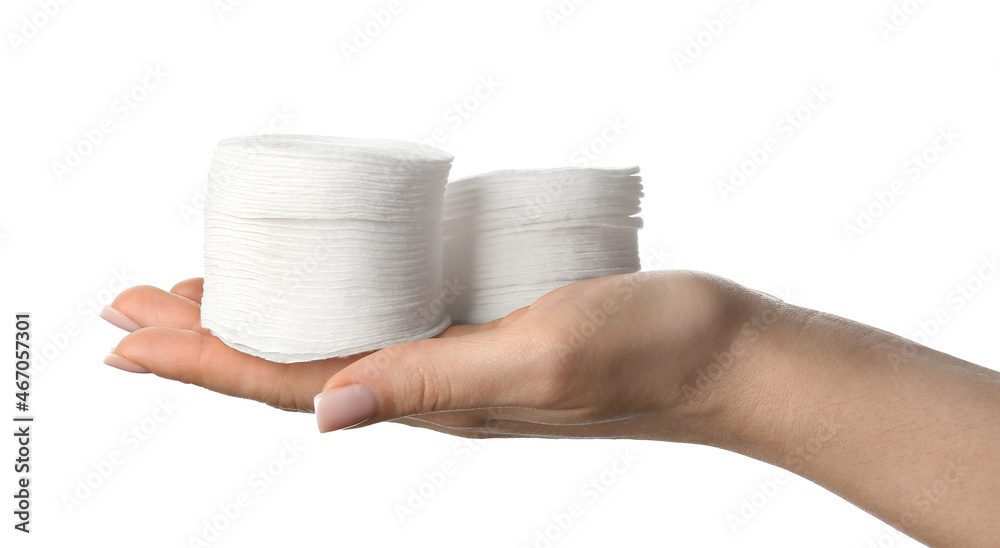 Female hand with stacks of cotton pad on white background