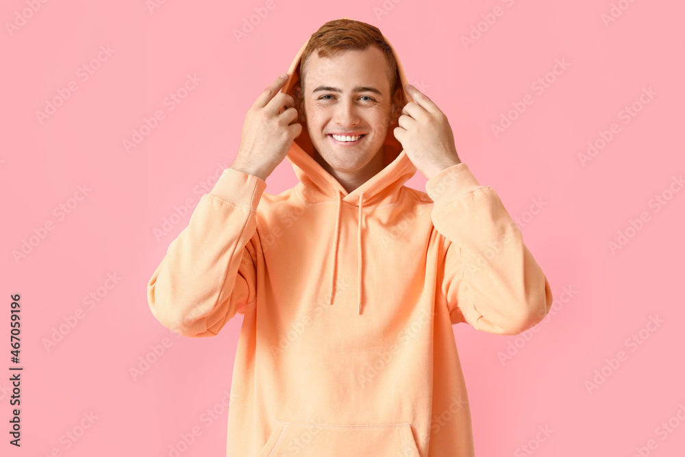 Young guy in stylish hoodie on color background