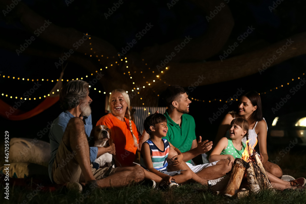 Happy family near fire on summer evening