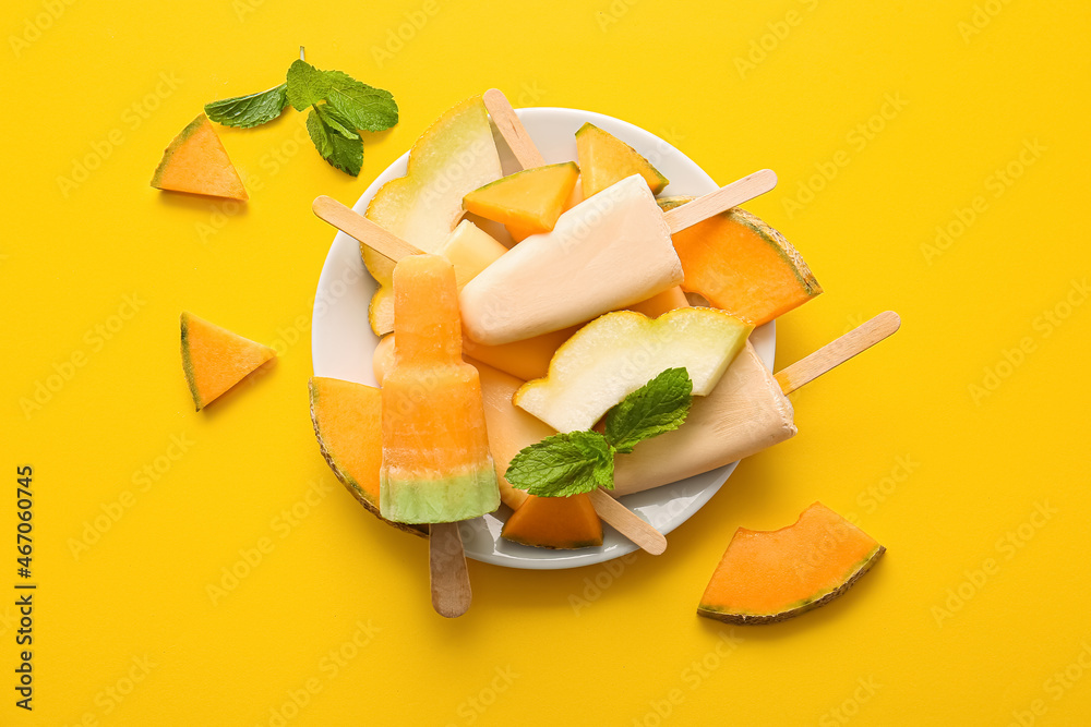 Plate with tasty melon popsicles on color background