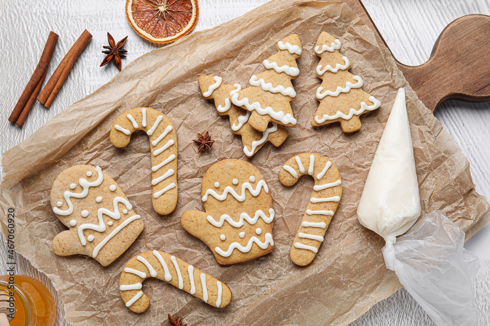 Board with Christmas gingerbread cookies on light background