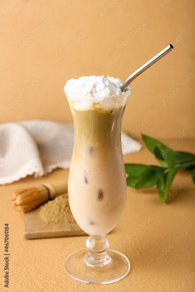 Glass of iced hojicha latte on beige background