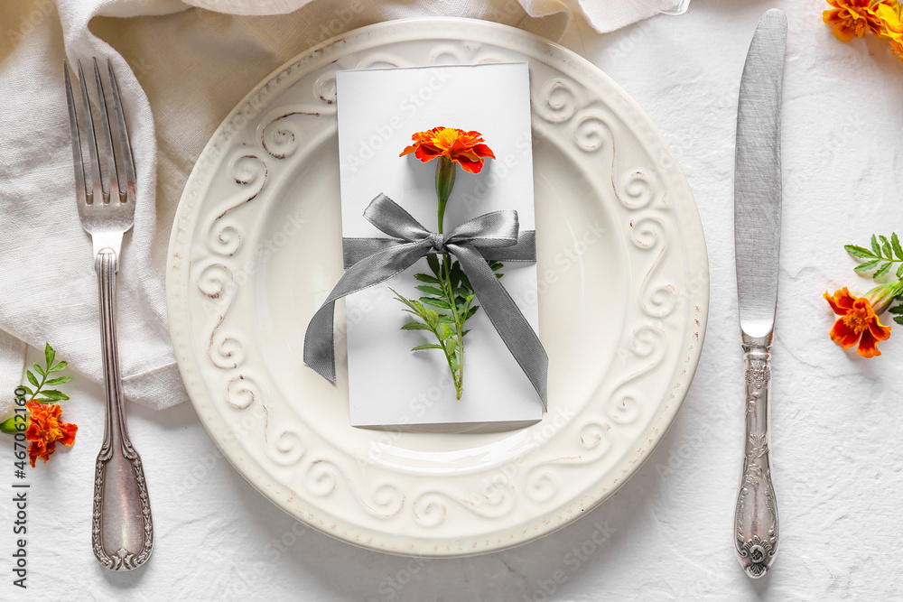 Beautiful table setting with marigold flowers on light background