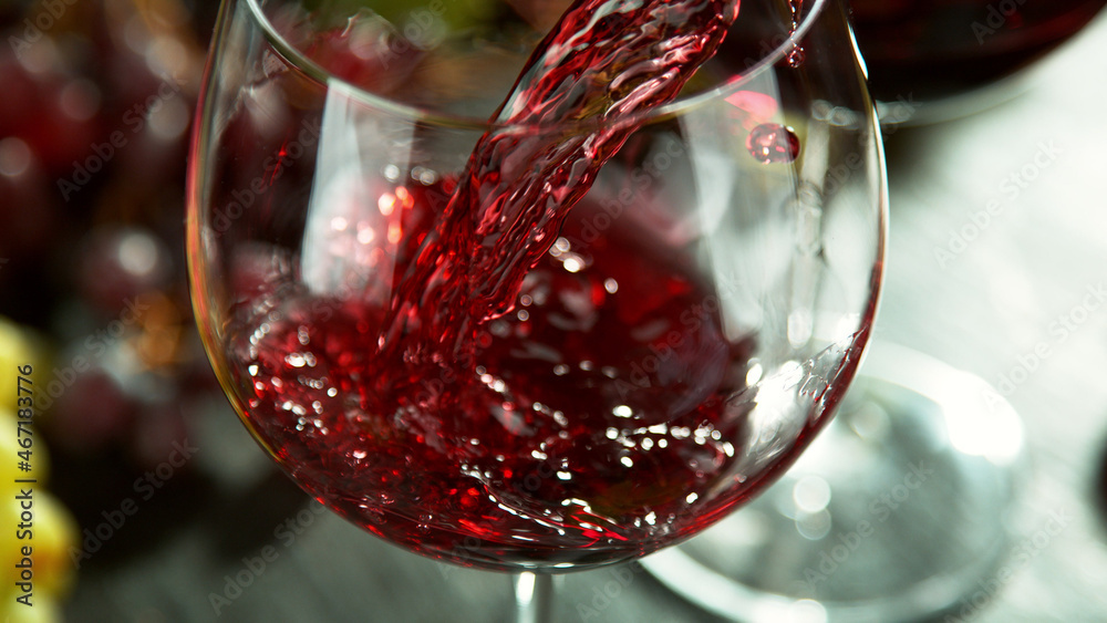 Macro shot of pouring red wine into glass.