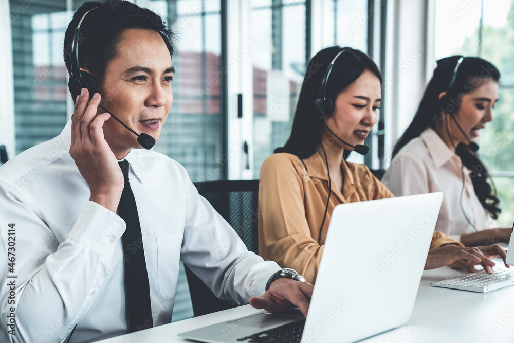 Business people wearing headset working actively in office . Call center, telemarketing, customer su