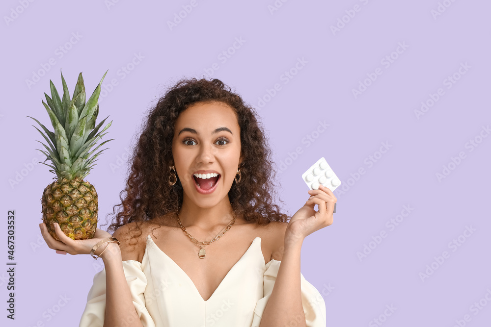 Happy African-American woman with chewing gum and pineapple on color background