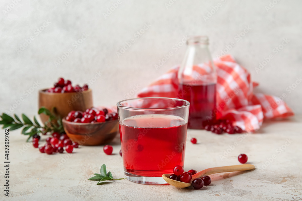 Glass with healthy cranberry juice on light background