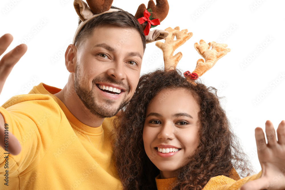 Happy couple with deer horns on white background