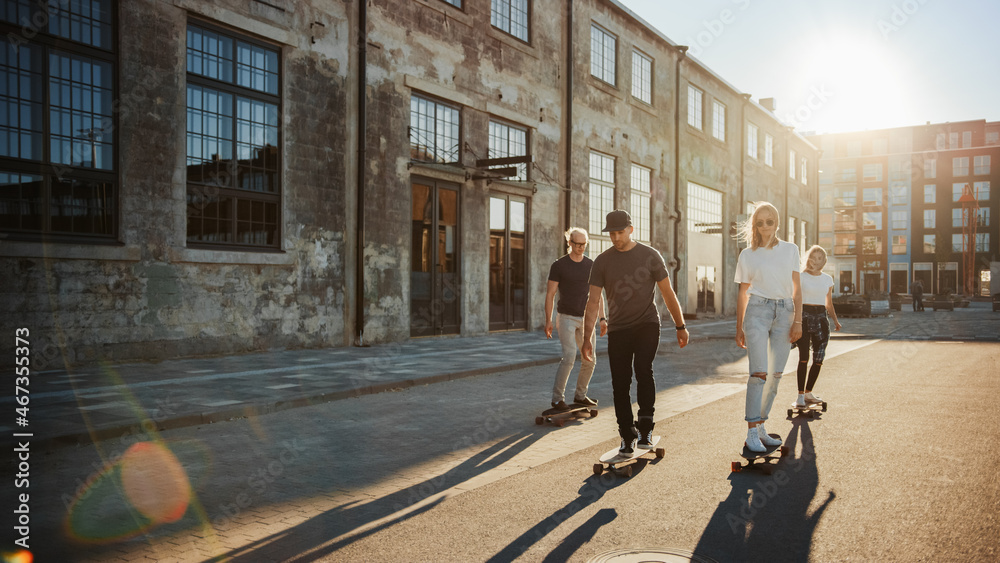 Group of Girls and Boys on Skateboards Through Fashionable Hipster District. Beautiful Young People 