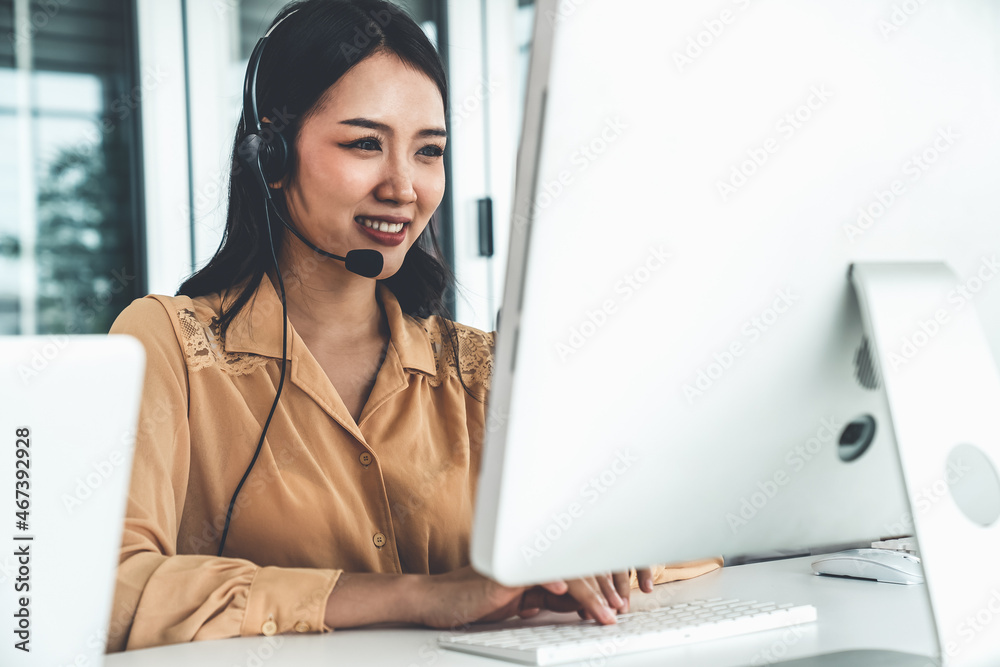 Businesswoman wearing headset working actively in office . Call center, telemarketing, customer supp