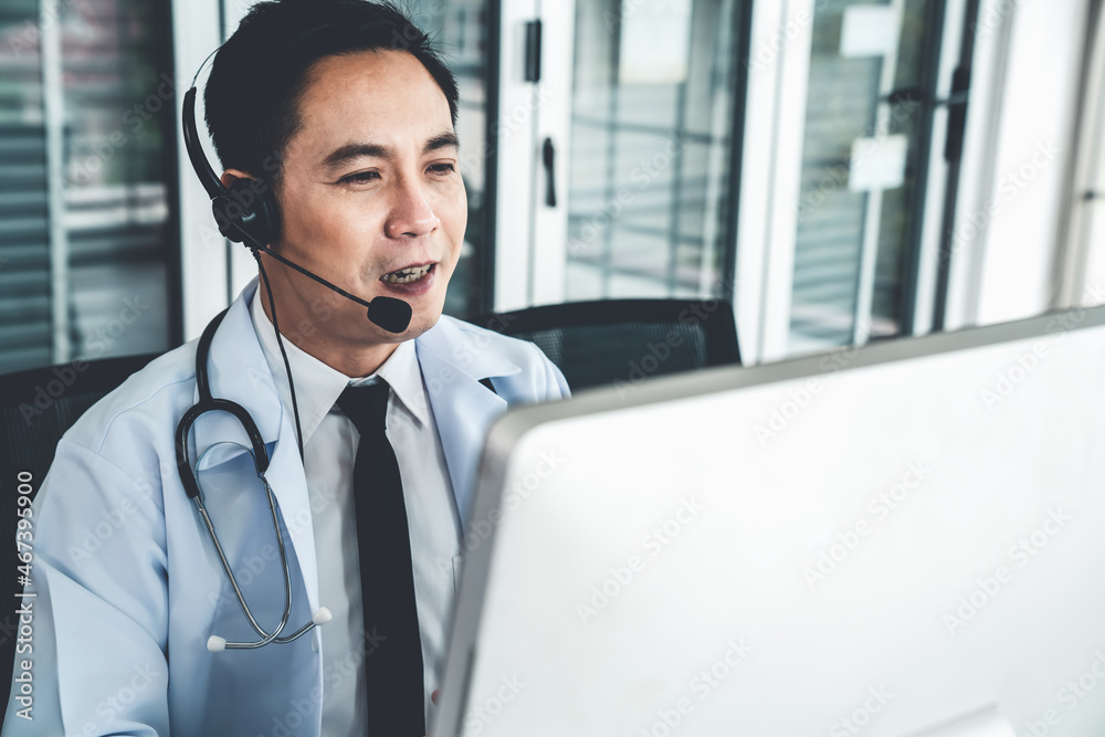 Doctor wearing headset talking actively on video call in a clinic or hospital . Concept of telehealt